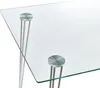 A close-up view of a modern glass-top dining table with silver hairpin legs. Náhled obrázku produktu