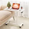A white C-shaped adjustable height table with a laptop, a small Christmas tree, and a coffee cup on it, placed next to a beige sofa. Produktbild-Vorschau