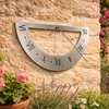 A sundial mounted on a stone wall, with flowers in the foreground. Produktbild-Vorschau