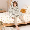 A young boy wearing a leopard-print hooded blanket sits on a bed with leopard-print bedding. Podgląd zdjęcia produktu