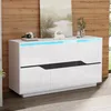 A modern white sideboard with black accents and blue LED lighting, displayed in a room setting with a wood-paneled wall and artwork. Voir les images du produit