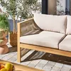 An outdoor seating area with a sofa and plants. Produktbild-Vorschau