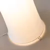 Close-up of the base of a white cylindrical floor lamp. Produktbild-Vorschau