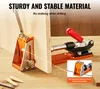 A jig tool is shown attached to a piece of wood, with a drill bit inserted. Another part of the jig is clamped to the wood. The scene is set on a wooden surface with some wood shavings and dowels visible. Náhled obrázku produktu