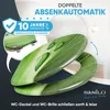 A toilet seat with a green leaf design, featuring water droplets, is shown in a dynamic pose. Promotional text and warranty information are overlaid. Produktbild-Vorschau
