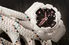 A white G-Shock watch with pink accents is placed on a thick white rope with blue and orange threads. Produktbild-Vorschau