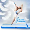 A gymnast performing a split jump on an air track mat, with feathers floating around. Podgląd zdjęcia produktu
