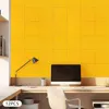 A modern office desk setup with a computer, lamp, and a wall covered in yellow acoustic panels. Podgląd zdjęcia produktu