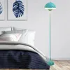 A bedroom scene with a bed and a floor lamp. Voir les images du produit