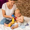 A mother and baby are playing with toys on a bed. Produktbild-Vorschau