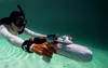 A person snorkeling underwater with a water scooter. Podgląd zdjęcia produktu