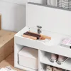 A close-up view of the interior of a white storage bench, showing shoe brushes, polish, and shoes stored in compartments. Anteprima dell’immagine prodotto