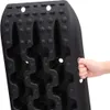 A hand is holding a black traction mat. Produktbild-Vorschau