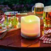 An outdoor table setting with a candle, beer, and appetizers. Produktbild-Vorschau