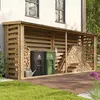 A wooden log store filled with firewood, next to two recycling bins and a watering can, situated on a paved patio area next to a house. Náhľad obrázku produktu