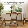 A rustic-style console table with storage shelves is placed in a well-lit room with a large window in the background. Podgląd zdjęcia produktu