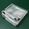 A folded clear tarp with reinforced corners and rope edging, laid on a dark green surface. Produktbild-Vorschau