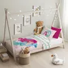 A child's bed with mermaid-themed bedding, decorated with fairy lights and framed pictures. Anteprima dell’immagine prodotto