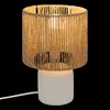 A table lamp with a white base and a woven shade. Produktbild-Vorschau
