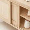 A close-up view of a wooden shoe bench with sliding doors and shelves, showing two pairs of shoes. Produktbild-Vorschau