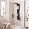 A modern bathroom with a black shower panel, a pink chair, and a window with dried plants. Náhľad obrázku produktu