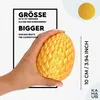 A hand holding a textured golden egg with text overlays. Voir les images du produit