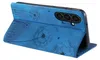 A blue flip case for a smartphone, decorated with embossed dandelion designs, is shown standing open. Produktbild-Vorschau
