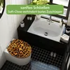 A bathroom scene featuring a toilet with a leopard-print seat and a sink. Produktbild-Vorschau
