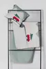 A pillow and a blanket with a Christmas car and tree motif are displayed on a black metal rack against a white background. Produktbild-Vorschau