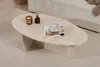 A travertine coffee table is placed on a rug in a living room setting, next to a sofa. Anteprima dell’immagine prodotto