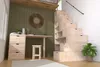 A room with a desk, stool, and a staircase-like shelving unit. Produktbild-Vorschau