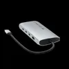 A silver USB-C multiport adapter with a black braided cable is shown against a black background. Produktbild-Vorschau
