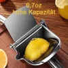 A close-up of a manual lemon juicer with a lemon inside, on a wooden surface. Produktbild-Vorschau
