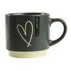 A gray ceramic mug with a gold heart design and a beige base, set against a white background. Náhled obrázku produktu
