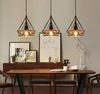 A dining room with a wooden table and chairs, illuminated by three pendant lights. Náhľad obrázku produktu