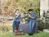 A couple is relaxing in a garden setting, sitting on a storage box. Produktbild-Vorschau