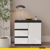 A modern sideboard with drawers and a door, placed in a room with a plant and a lamp. Produktbild-Vorschau
