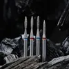 Four diamond burrs are arranged in a row on a dark, rocky surface. Anteprima dell’immagine prodotto