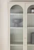 A close-up view of a beige vitrine with fluted glass doors. Voir les images du produit