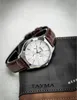 A watch is placed on top of a wallet. Produktbild-Vorschau