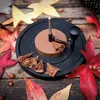 A chocolate shaving tool is shown creating curls from a block of chocolate, surrounded by autumn leaves and hazelnuts on a wooden surface. Produktbild-Vorschau