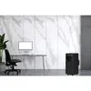 A black portable air conditioner is placed on the floor next to a desk with a computer and chair in an office setting with a marble-patterned wall. Produktbild-Vorschau