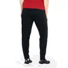 A person wearing black polyester pants and a red shirt, viewed from the back. Produktbild-Vorschau