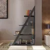 A modern, angular bookshelf filled with books and decorative items, placed against a wall with patterned wallpaper. A bedside table with a lamp is visible to the right. Náhled obrázku produktu