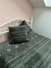 A close-up view of a bed with gray bedding and pillows featuring a white geometric pattern. Anteprima dell’immagine prodotto
