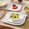 A table setting with a porcelain dinnerware set, featuring various dishes filled with food. Náhled obrázku produktu