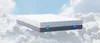 A mattress floating on clouds against a blue sky. Produktbild-Vorschau