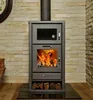 A wood-burning stove with a fire burning inside, set against a stone wall. Produktbild-Vorschau