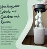 A person is using a diaper disposal system, with several wrapped diapers hanging from it. The system is placed inside a white bin. Produktbild-Vorschau