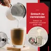 A close-up of frothed milk being poured into a glass of coffee, with text overlays and a smaller inset image of frothing equipment. Produktbild-Vorschau
